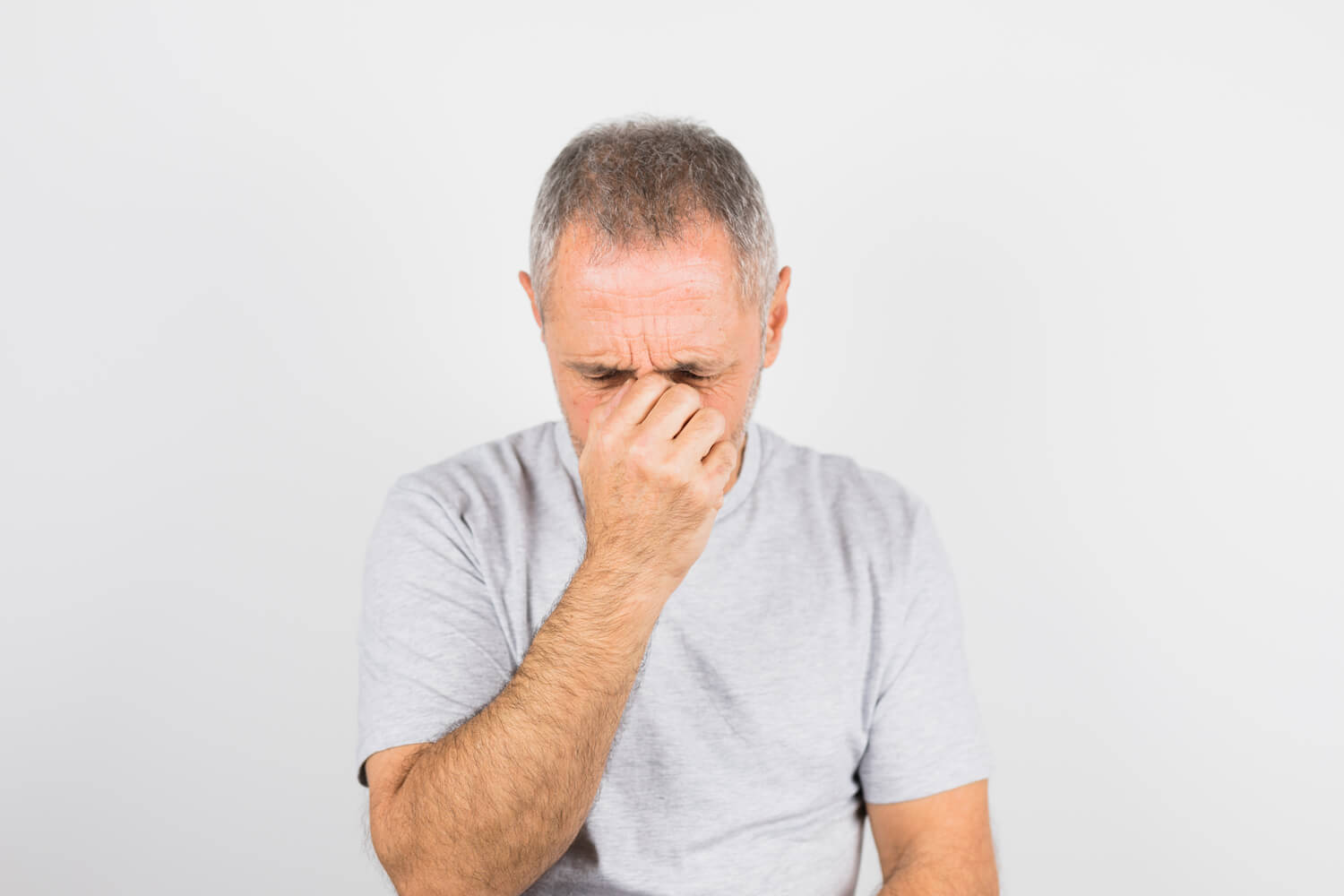 Man in pain with hands over his eyes 