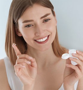 Woman holding contact lenses